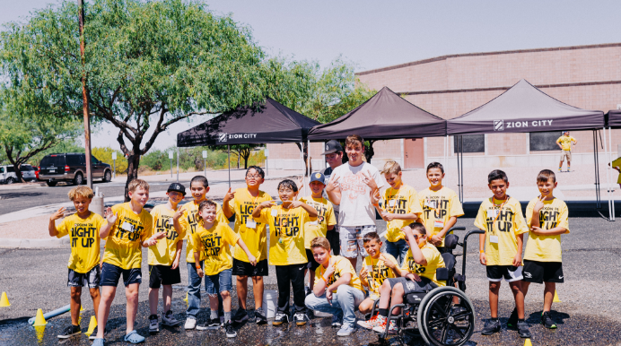 Gratitude Day volunteers with children in yellow shirts